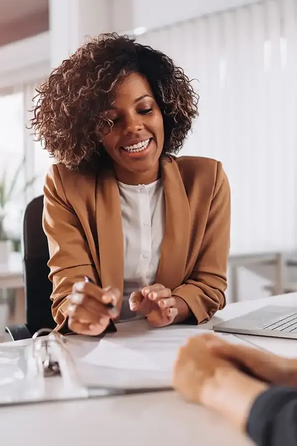 A smiling Bloom product specialist at a desk during a one-on-one cannabis product consultation