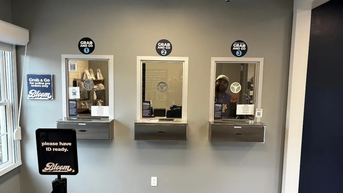 Three service windows with order-number signs at the express pickup area of Bloom Painesville