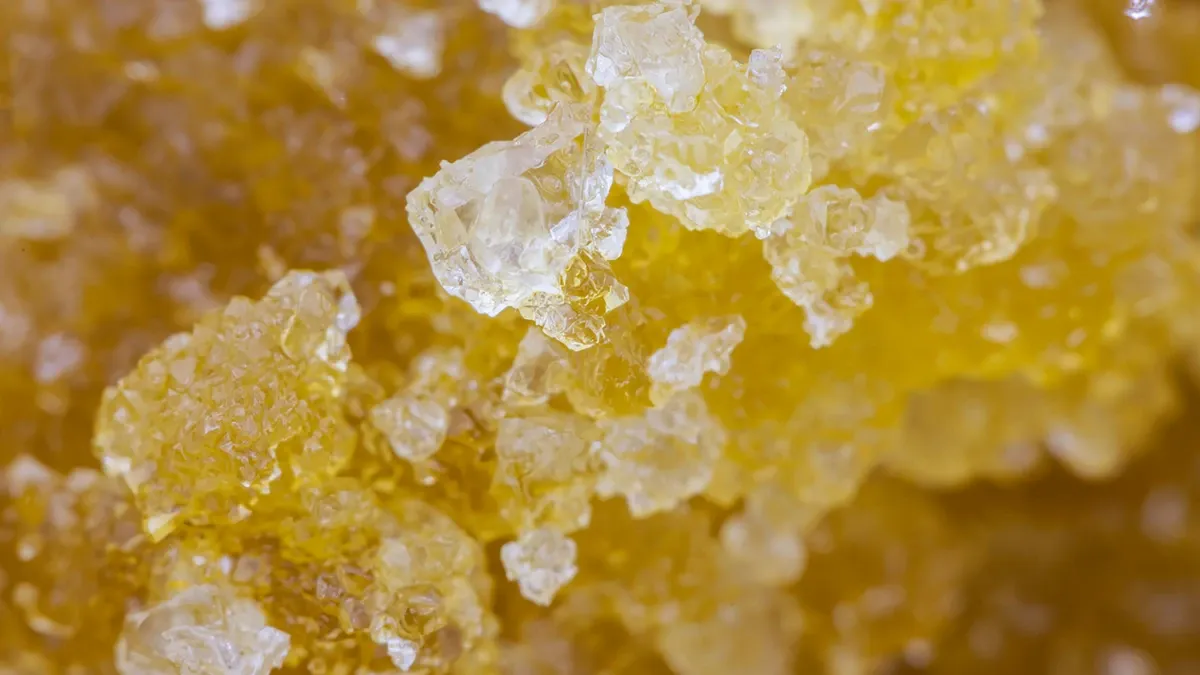 Close-up of golden, crystalline cannabis concentrate, a live resin sugar texture