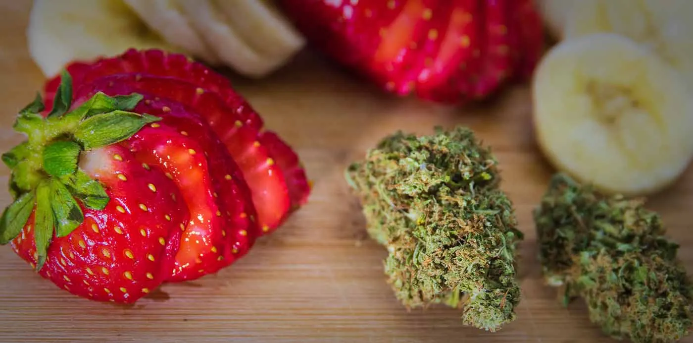 Cannabis buds next to sliced strawberries and banana, showing complementary flavors