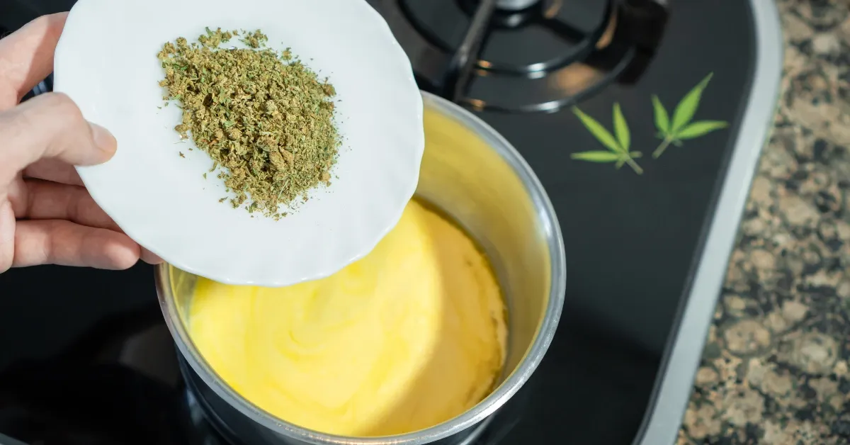 Pouring decarboxylated ground cannabis from a plate into a saucepan of melted butter on the stove to make cannabutter