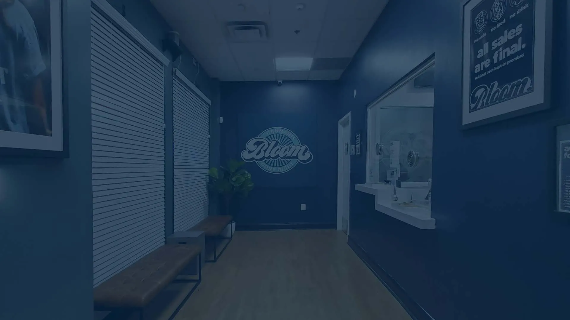 Check-in hallway at the Bloom Germantown dispensary in Maryland, with the Bloom logo on the back wall, benches and a service window.