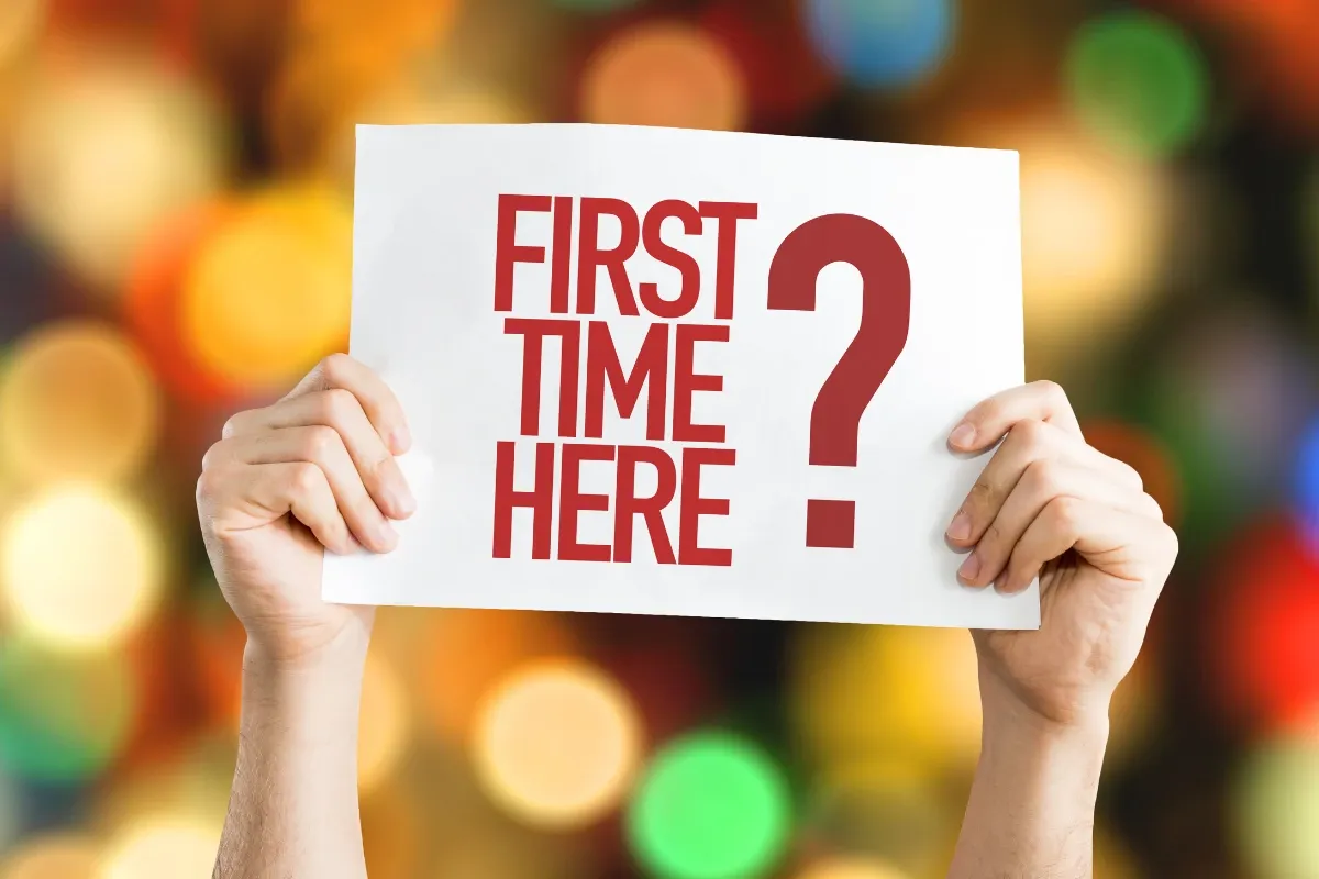 Hands holding a 'First time here?' sign, for a first visit to an Ohio cannabis dispensary