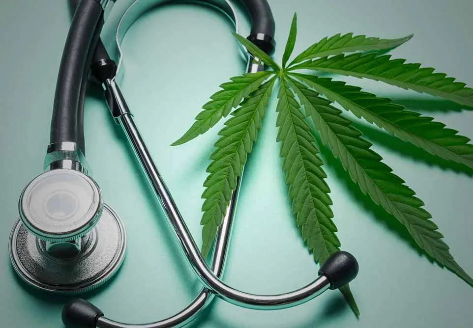 Stethoscope beside a green cannabis leaf on a teal background, representing medical marijuana
