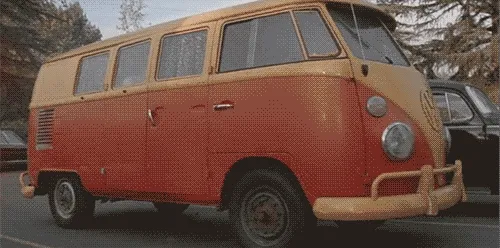 Vintage orange Volkswagen bus parked on a street