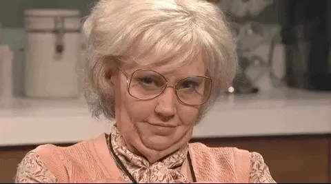 Comedy sketch clip of a gray-haired woman in glasses giving a suspicious sideways look