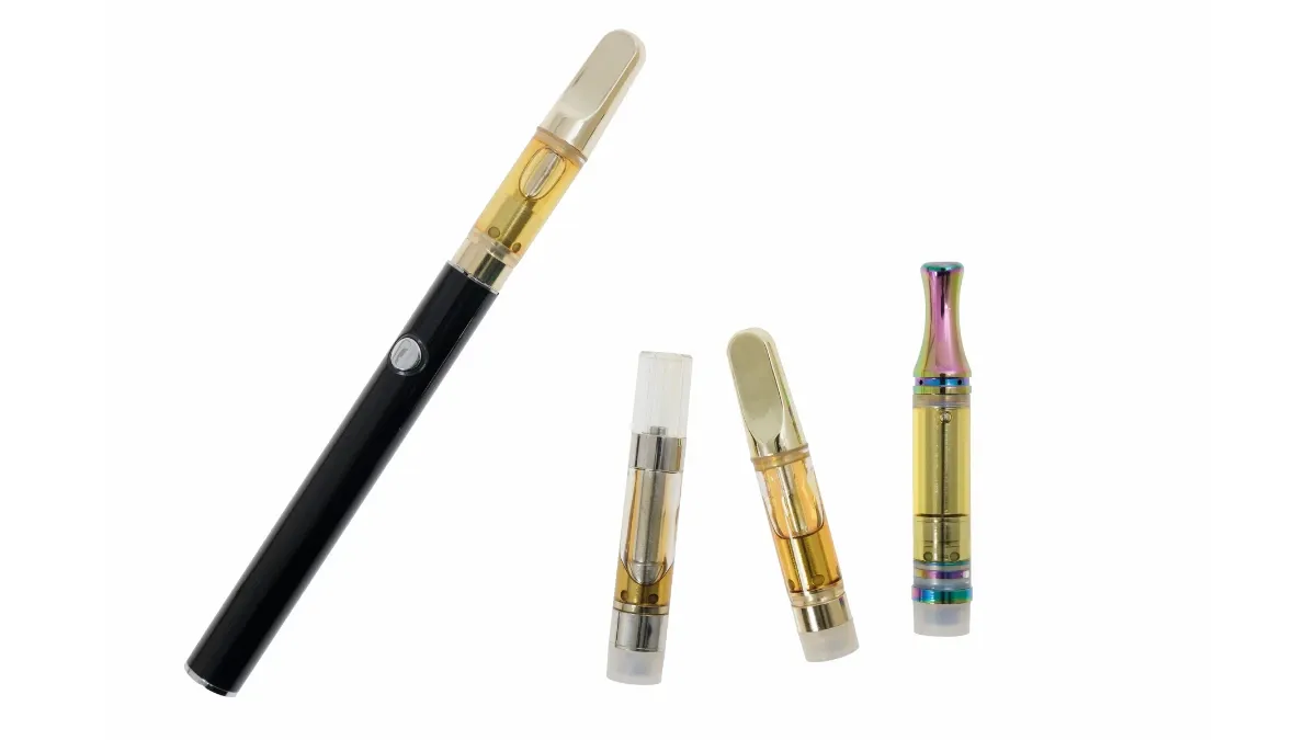 Black 510-thread vape battery beside three cannabis oil vape cartridges of different styles