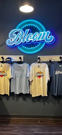 Bloom T-shirts hanging beneath a blue neon Bloom sign at the Bloom dispensary in West Columbus, Ohio.