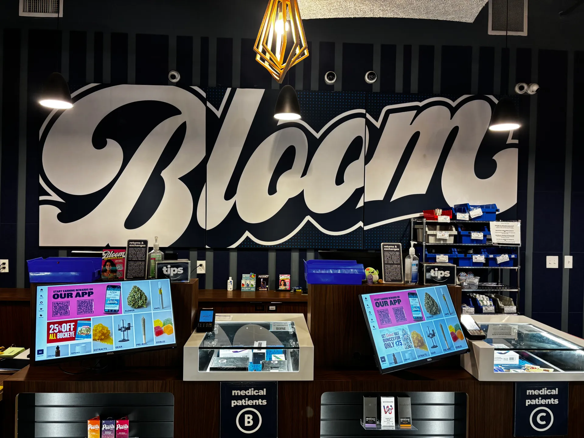 Sales counter at Bloom West Columbus dispensary with a large Bloom mural on the wall behind it.